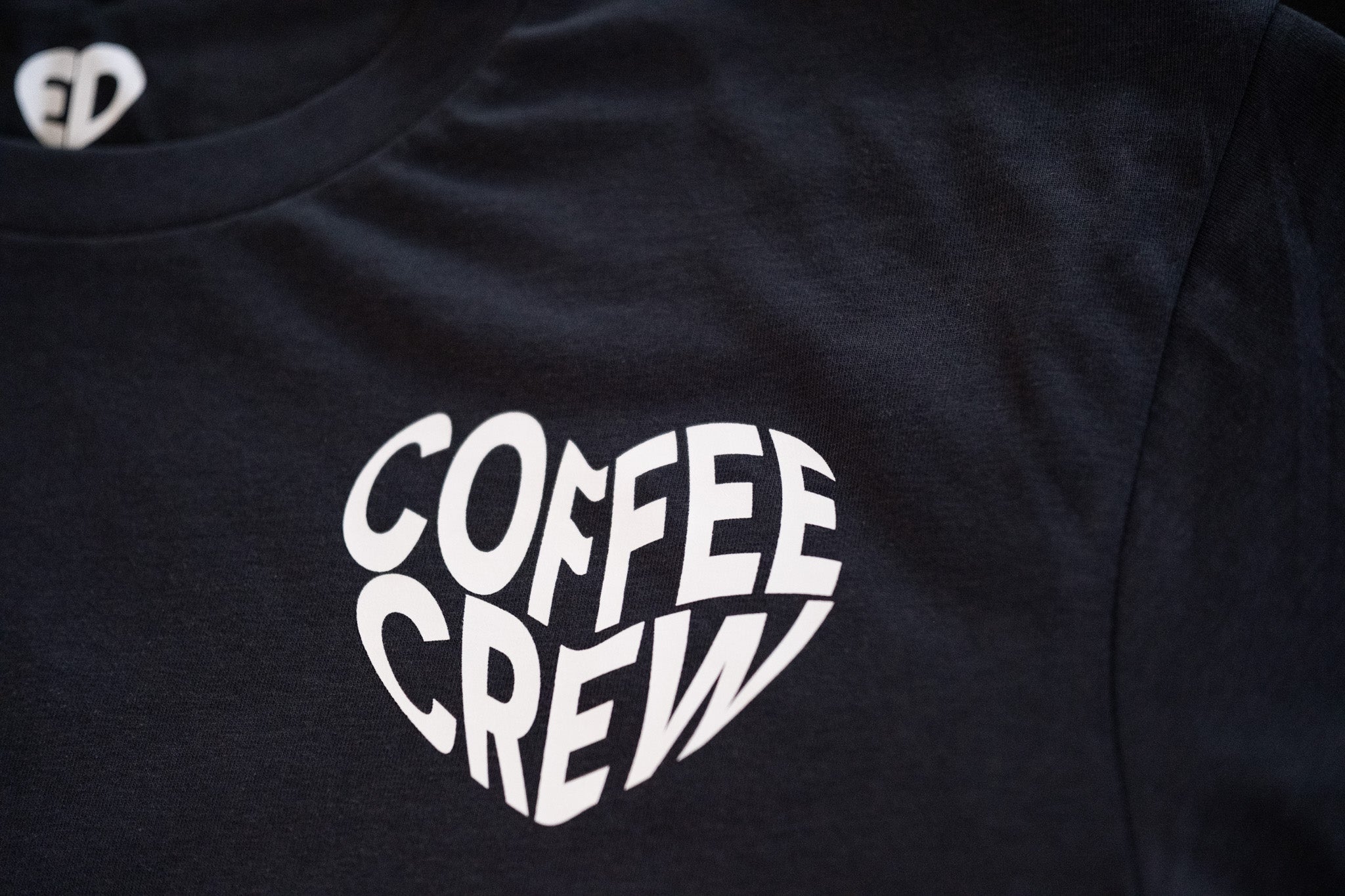 Black t-shirt with 'Coffee Crew' design on a dark background