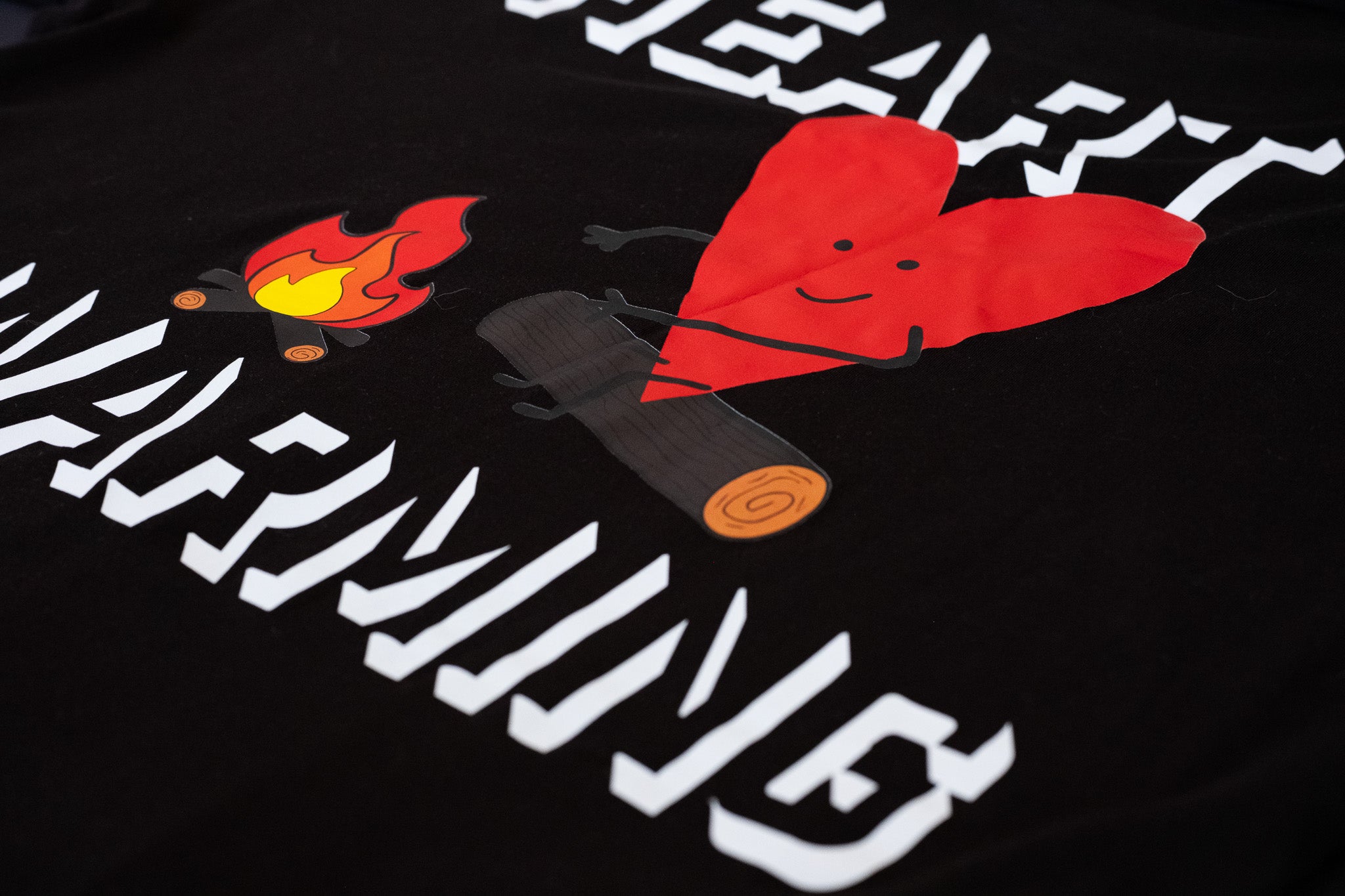 Black t-shirt with white text and red heart design on a dark background