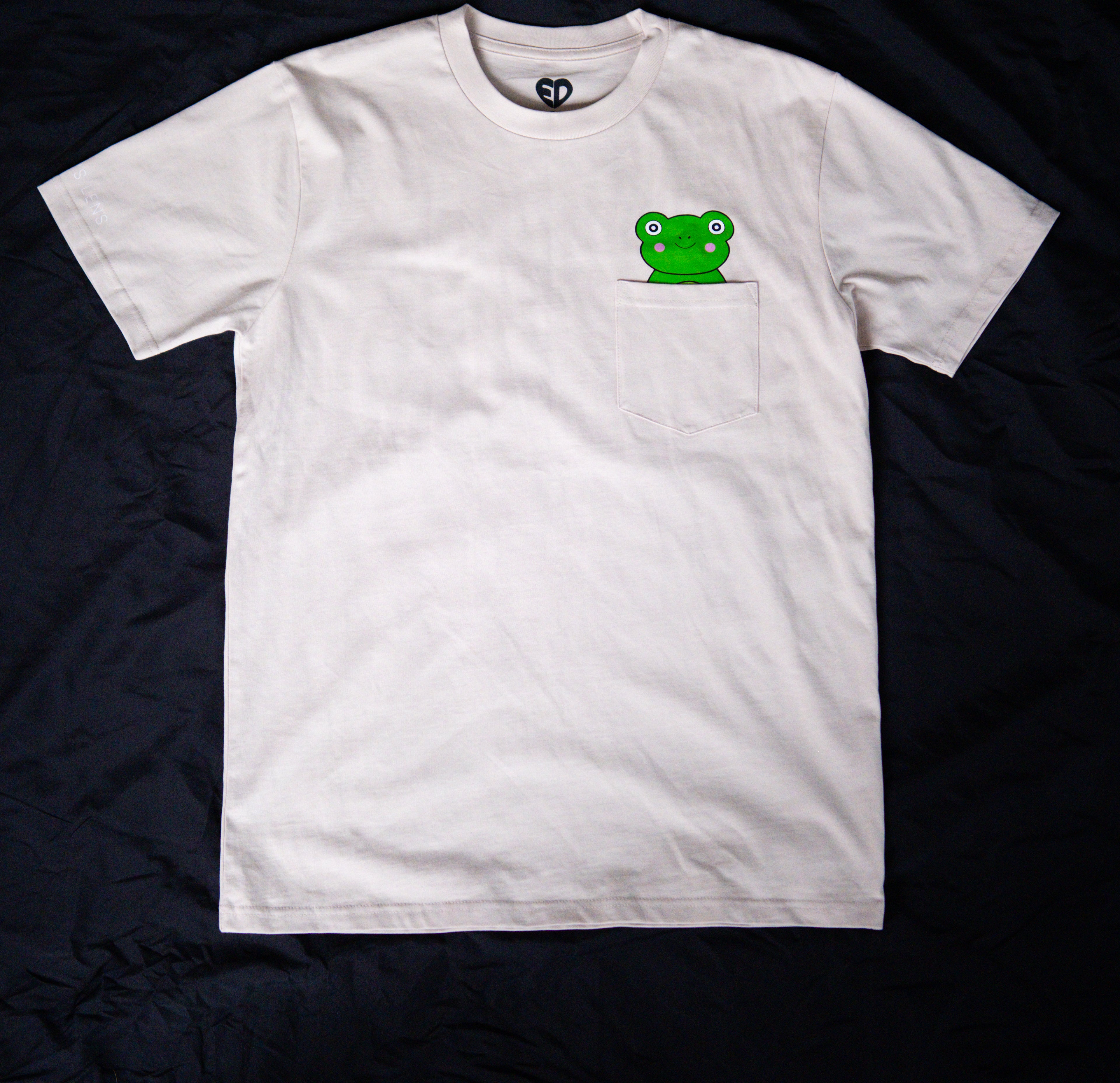 White t-shirt with a green frog graphic on a black background