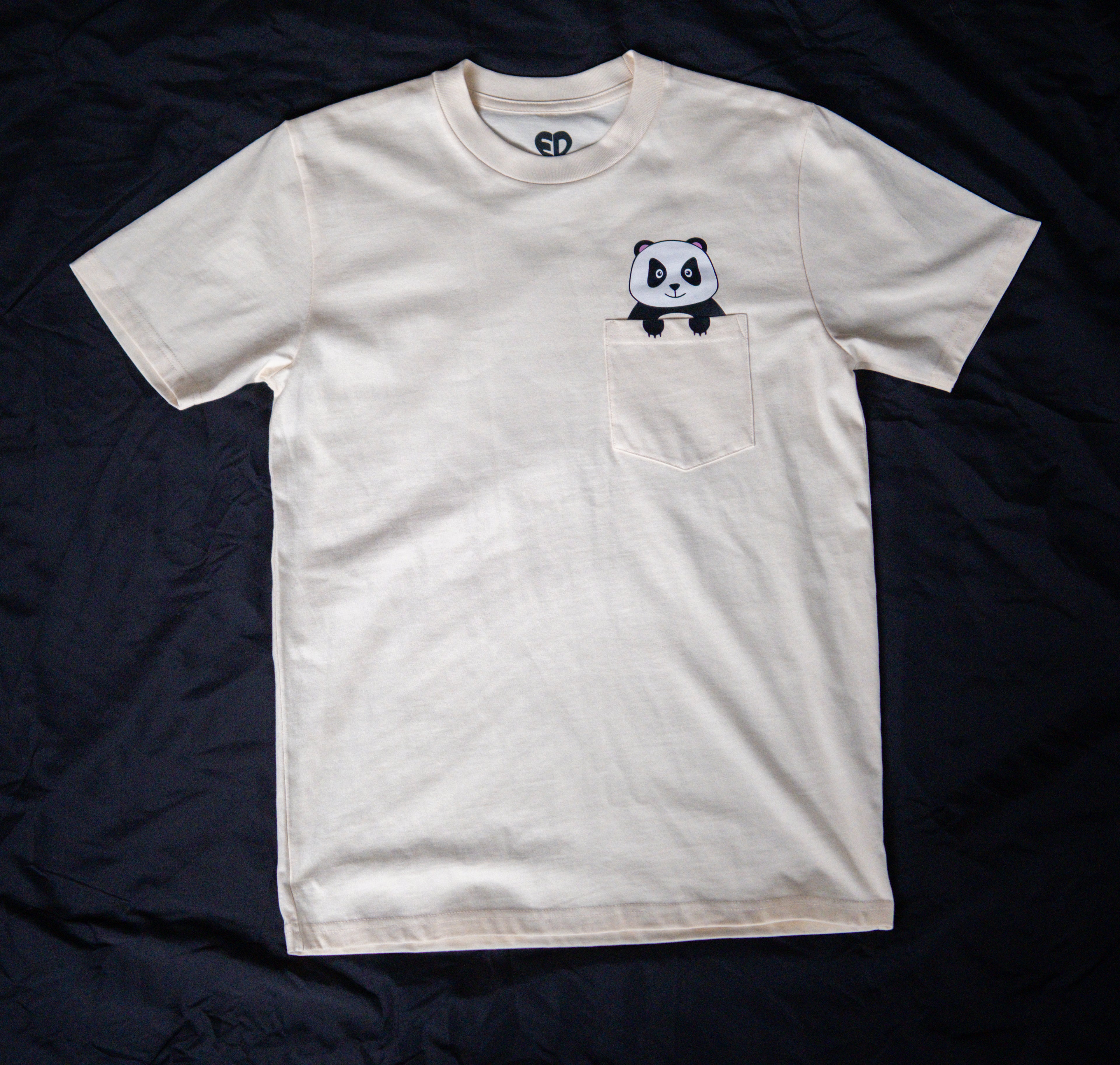 Beige t-shirt with a panda graphic on a dark background