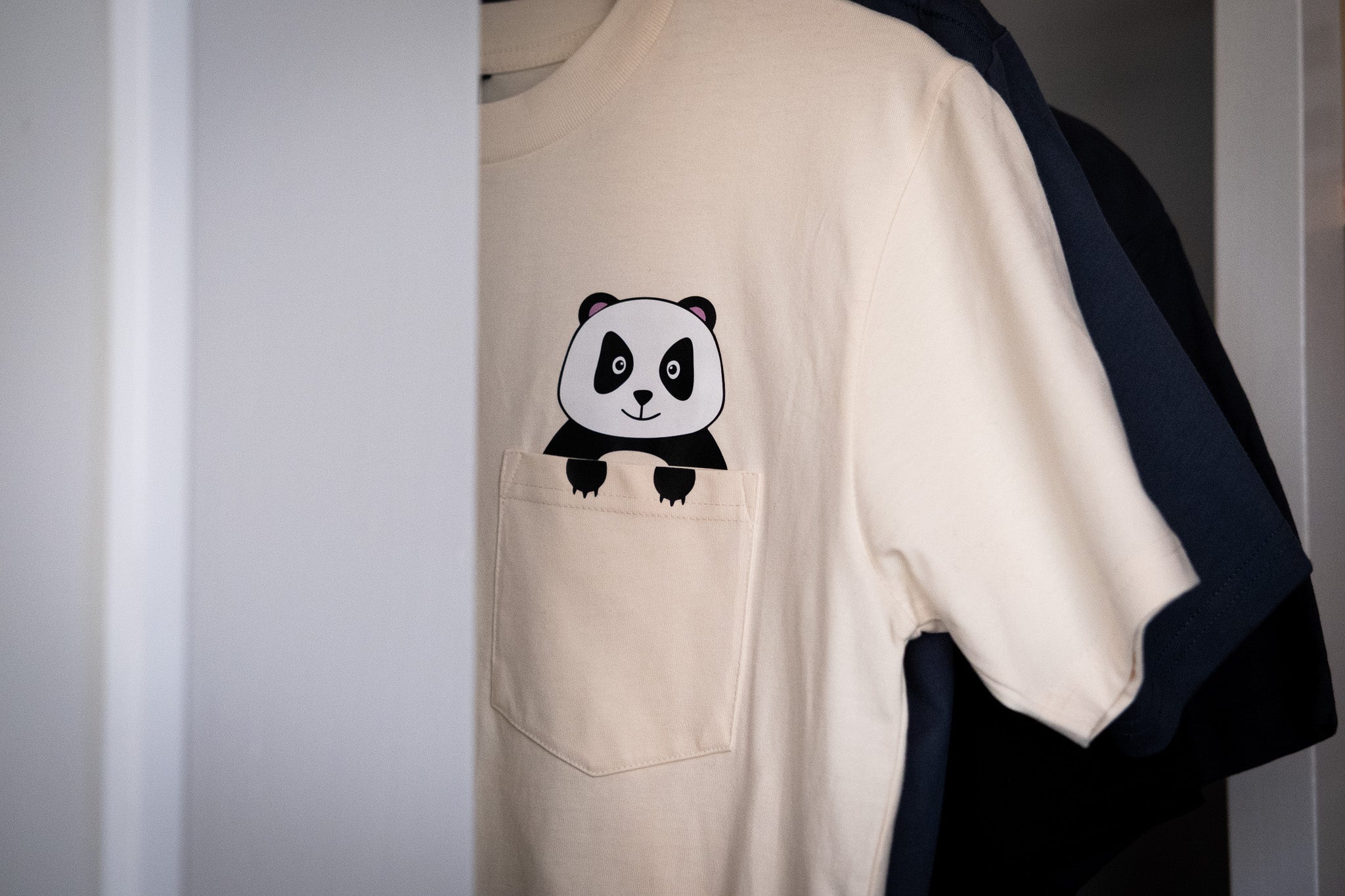 Beige t-shirt with a panda design on a white background