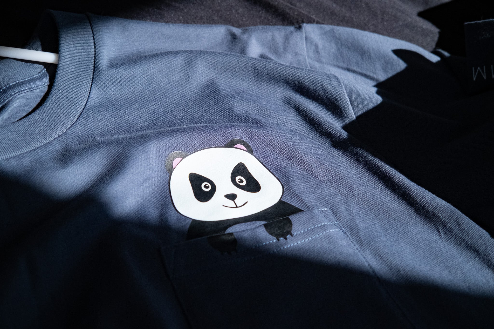 Blue t-shirt with a panda design on a dark background